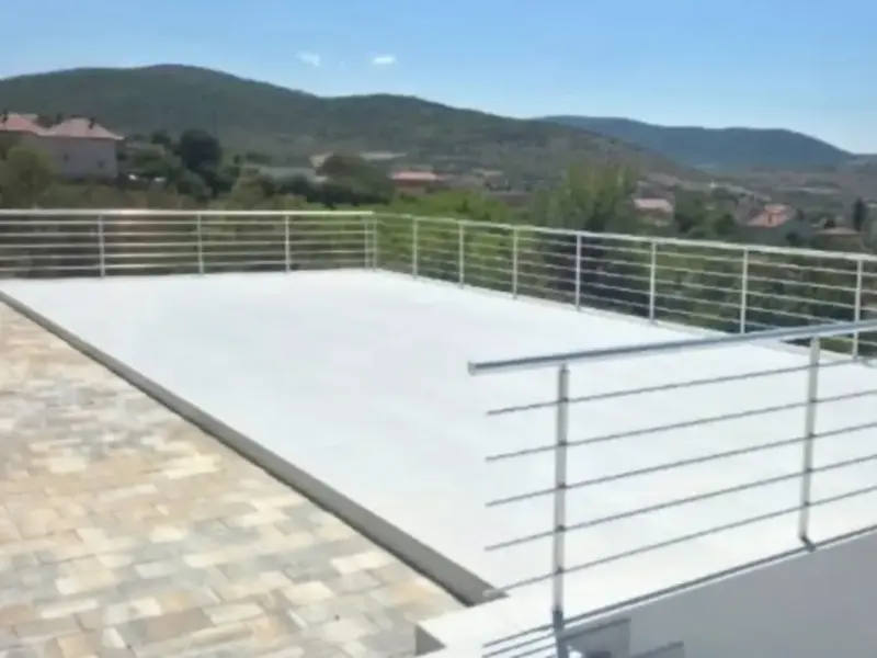 Ravan krov kuće s aluminijskom ogradom od horizontalnih cijevi, pogled na brda